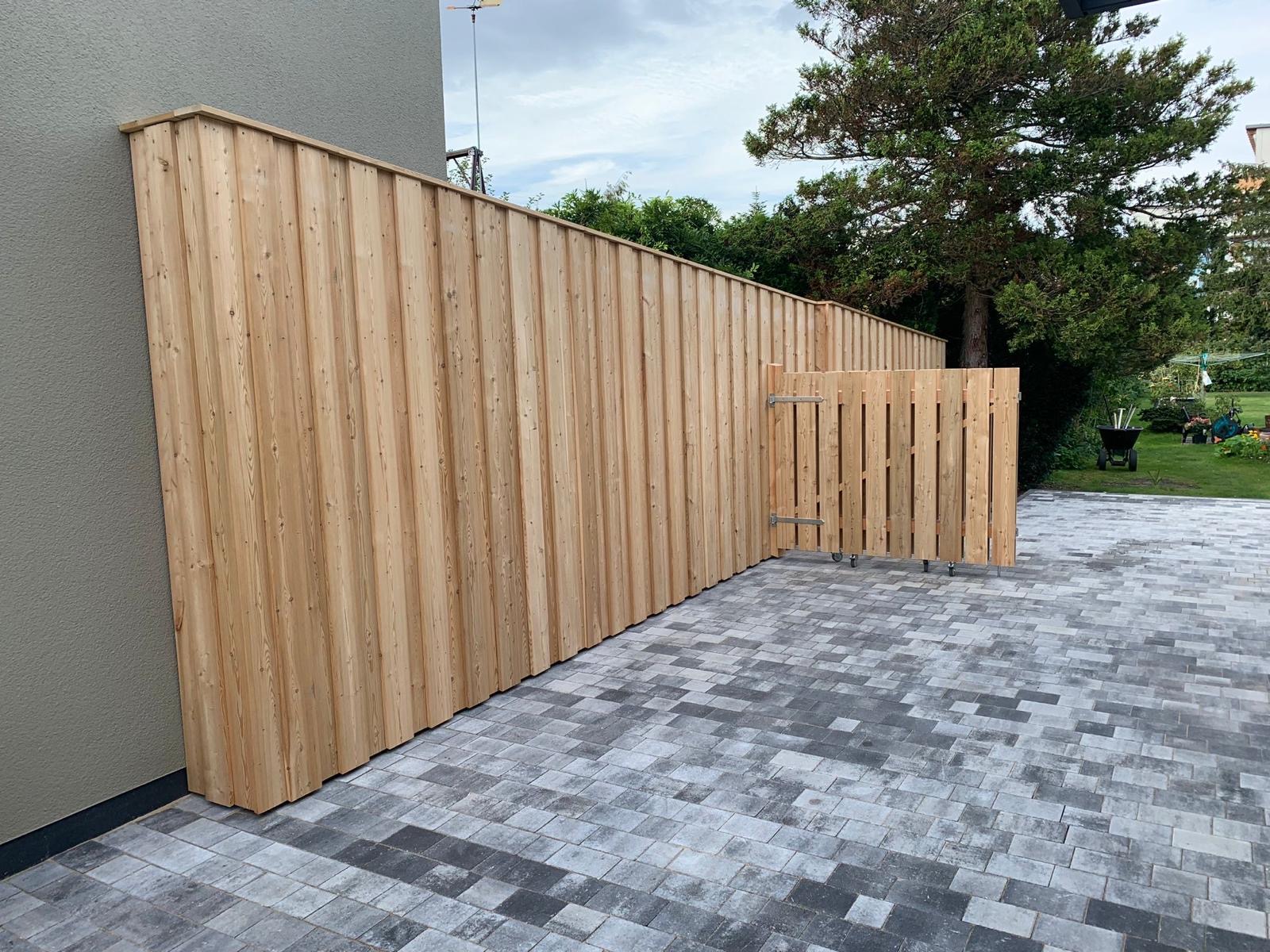 Langer Sichtschutzzaun aus Holz mit passendem Gartentor