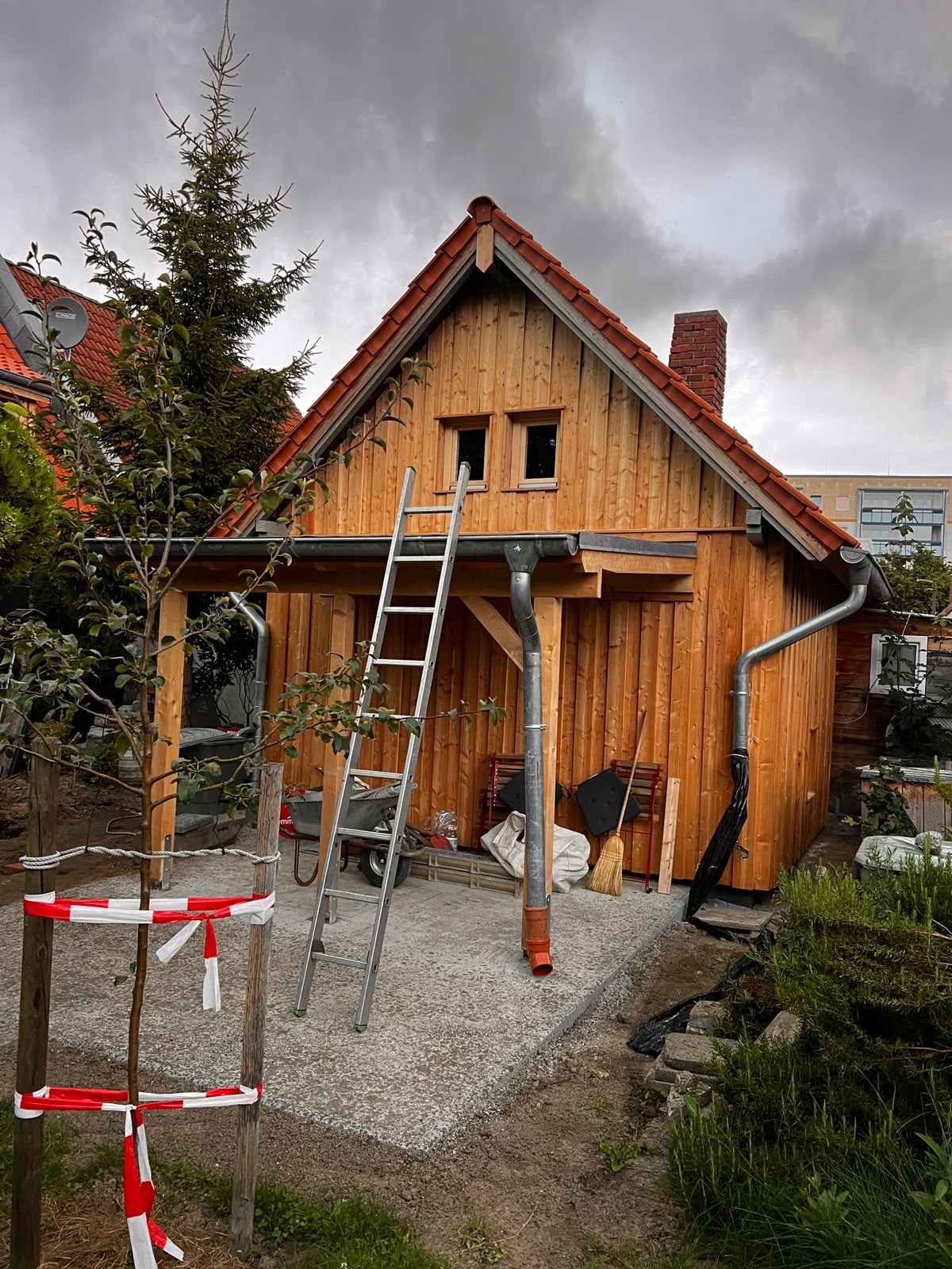 Holzgebäude mit Satteldach und Ziegeleindeckung kurz vor der Fertigstellung
